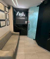 Lobby de clínica de diseño de sonrisa en Barranquilla con ambiente premium y logo iluminado